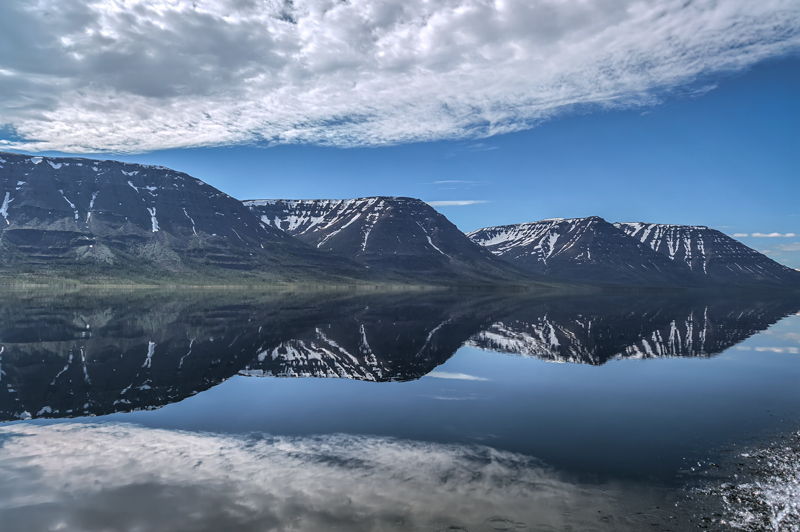 Озеро с отражением скальных склонов на Плато Путорано